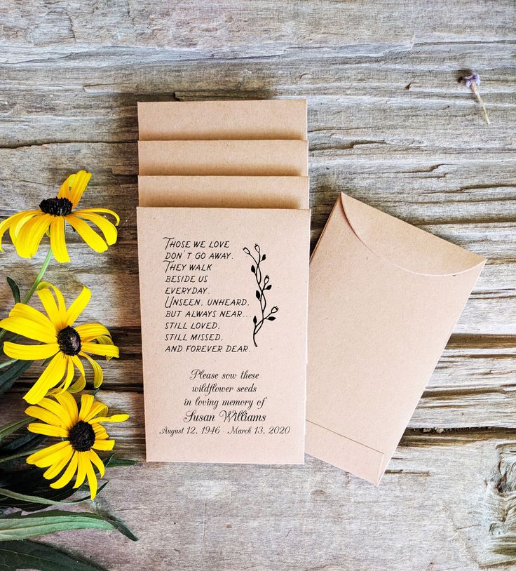 some yellow flowers are next to a brown envelope with a poem on it and two small cards