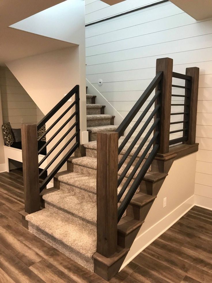 the stairs in this house are made of wood and metal, while carpet is on the floor