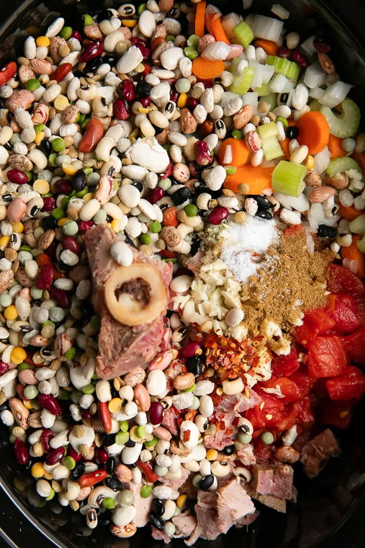 a large bowl filled with lots of different types of vegetables and meat on top of it