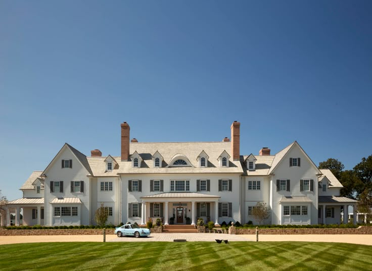 a large white house sitting on top of a lush green field