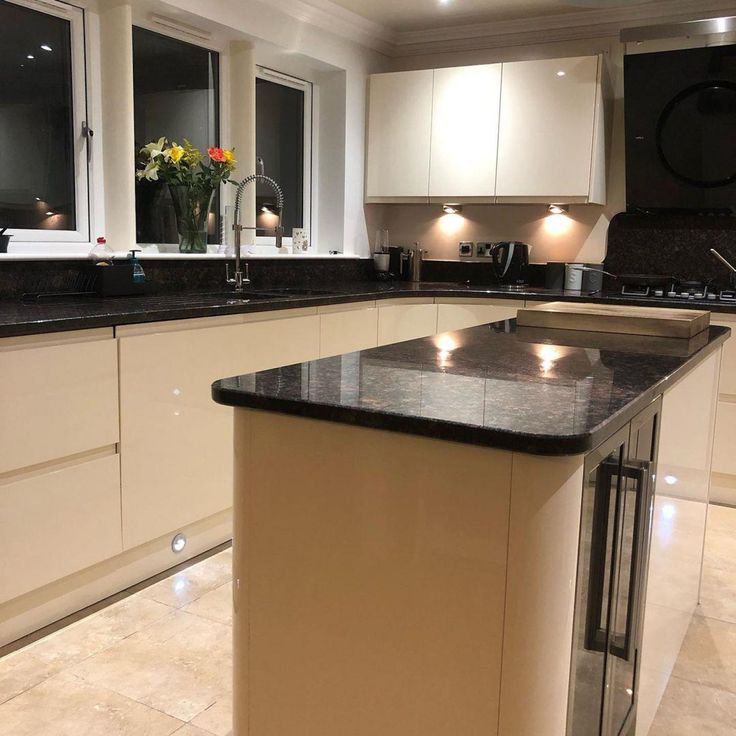 a kitchen with white cabinets and black counter tops