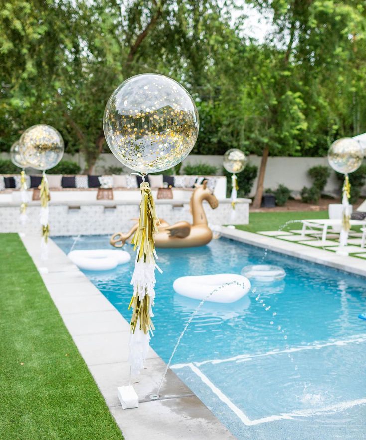 an inflatable ball and streamer are on the edge of a pool