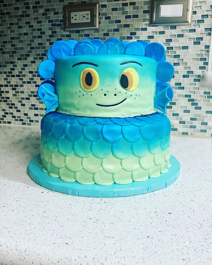 a blue and green cake sitting on top of a counter