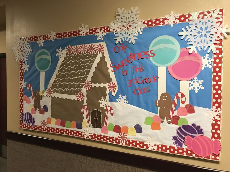 a bulletin board is decorated with gingerbread houses and snowflakes on the wall