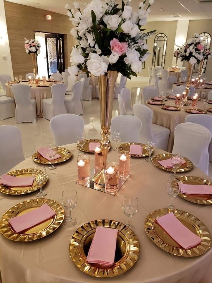 the table is set with pink napkins and gold plates