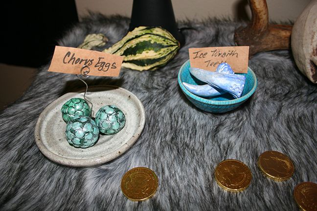 there are three eggs in a bowl on the table next to some coins and other items