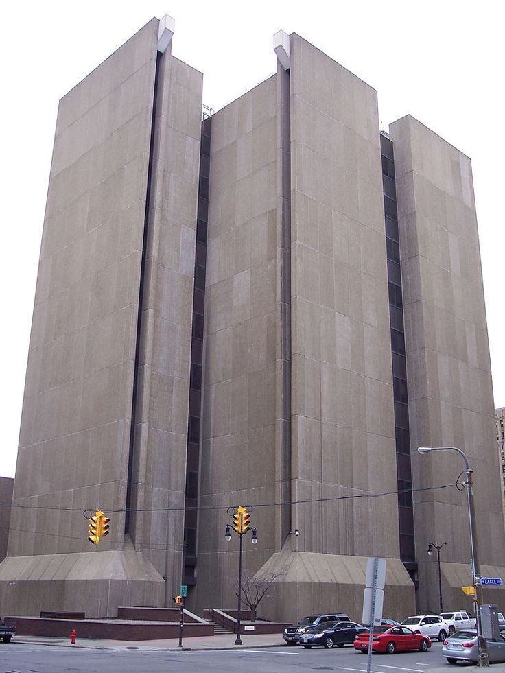 the large building has two tall towers on it's sides and is next to a traffic light