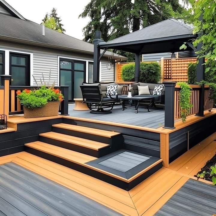 an outdoor deck with steps leading up to it and potted plants on the other side