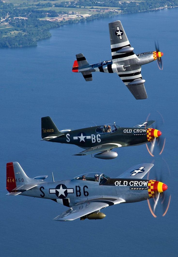 four fighter jets flying in formation over the ocean