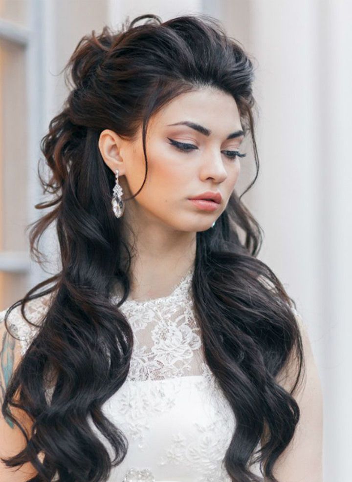 a woman with long black hair and earrings on her head, wearing a wedding dress