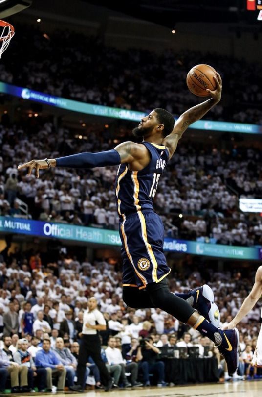 a basketball player is jumping up to dunk the ball in front of an audience