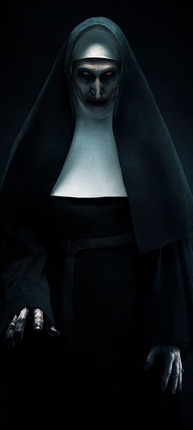 a nun in the dark with her hands on her hips