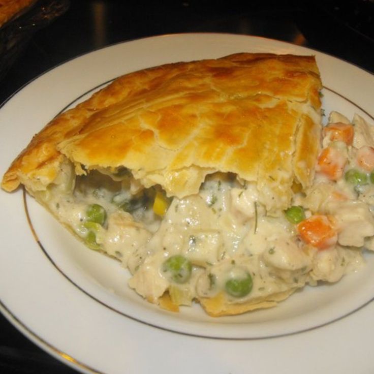 chicken pot pie on a plate with a piece cut out to show it's filling