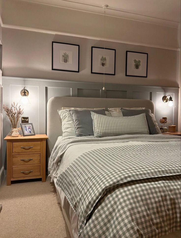 a large bed sitting in a bedroom next to two framed pictures on the wall above it