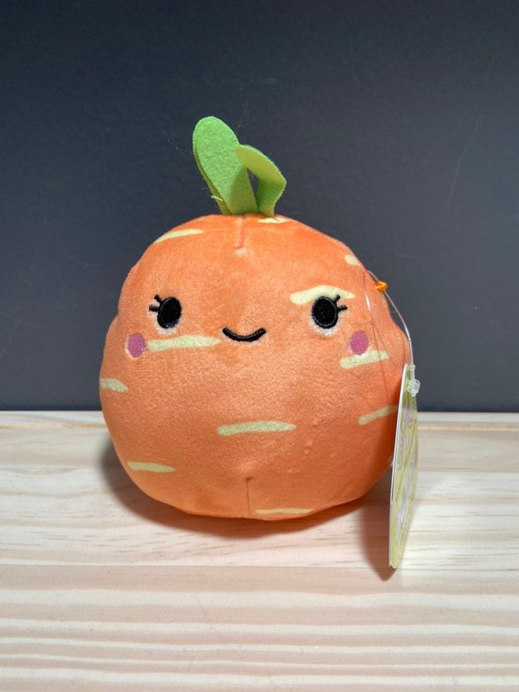 an orange stuffed toy sitting on top of a wooden table