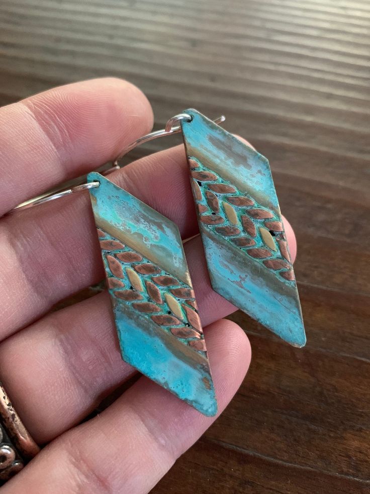 These earrings feature mixed metals of solid, gold brass & raw copper and are finished with a unique turquoise verdigris patina. The patina has been sealed with a good coating of renaissance wax but should not be worn while showering or bathing to maintain patina. The ear wires are forged by hand from 20g Sterling silver. These earrings have a celtic / tribal feel. They are versatile and suitable for just about any style, from modern to rustic. They're substantial but comfortable to wear. Th Copper Dangle Jewelry With Patina, Copper Dangle Earrings With Patina, Blue Artisan Copper Earrings, Artisan Blue Copper Earrings, Unique Blue Copper Earrings, Earthy Nickel-free Copper Jewelry, Soldered Turquoise Brass Earrings, Turquoise Soldered Brass Earrings, Gold Bohemian Earrings With Patina