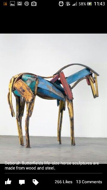 a sculpture of a horse made out of metal and wood with paint on it's body