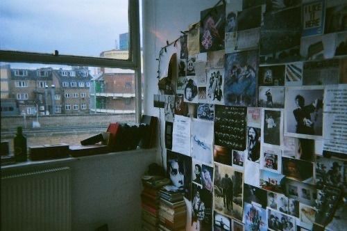 there is a wall with many pictures on it in the room next to a window