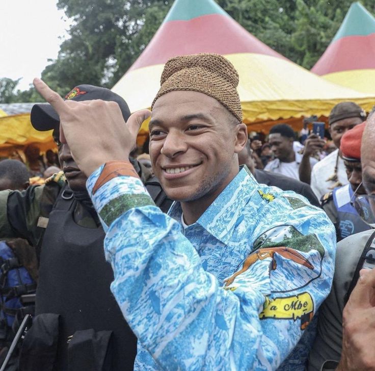 a man taking a selfie with his cell phone in front of a crowd of people