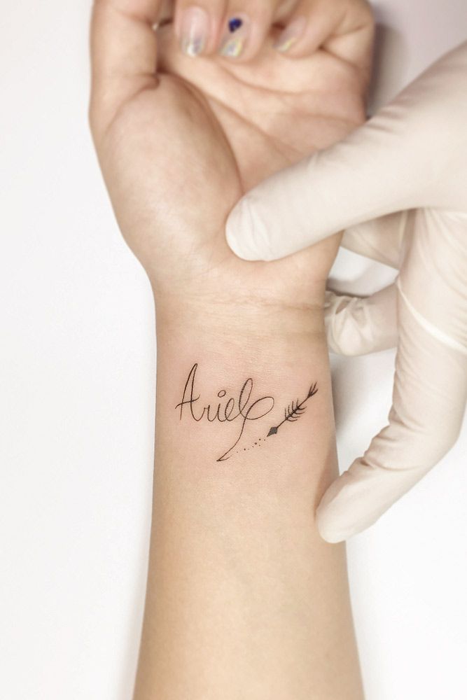 a woman's wrist tattoo with the word ariel written in cursive writing