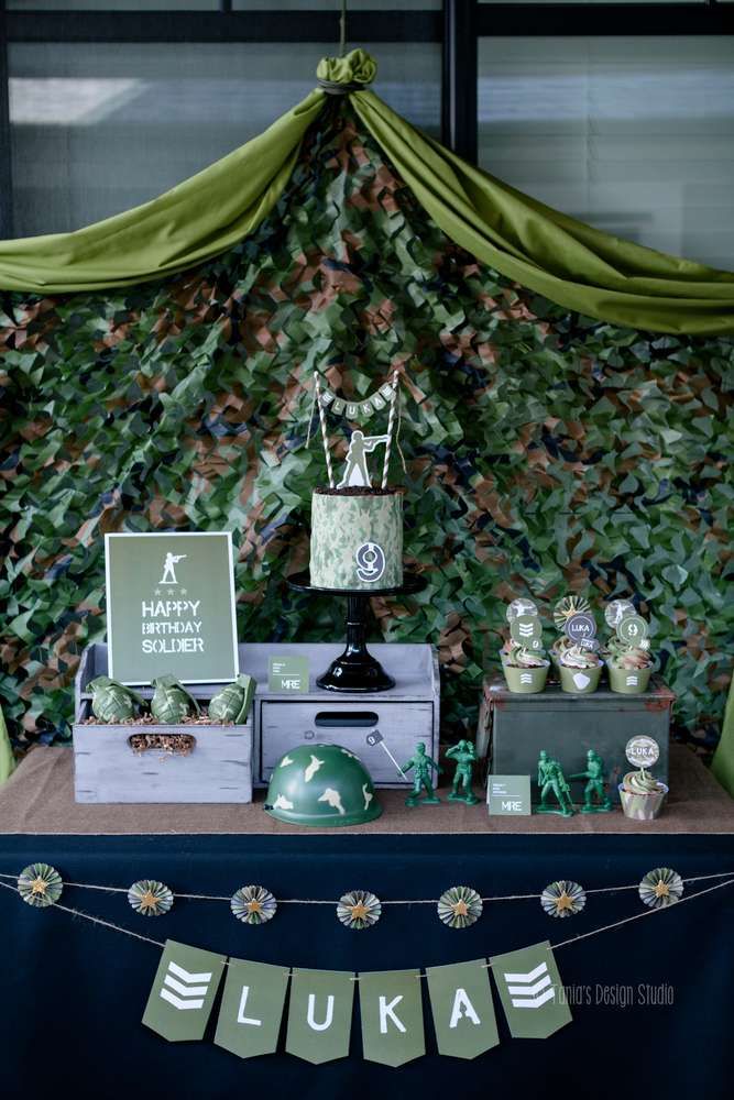 a table topped with cake and cupcakes next to a wall covered in leaves