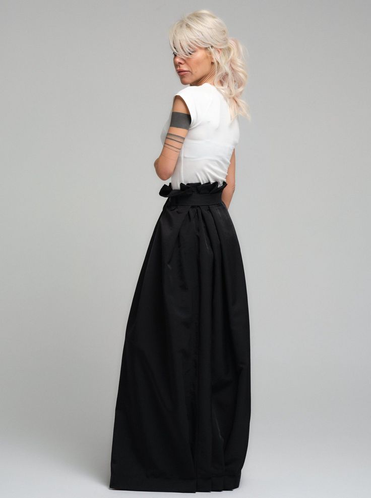 Make a bold statement with our high-waist skirt, the epitome of tailored elegance. This skirt is fashioned from premium polyester, delivering a smooth finish with a substantial feel that gracefully flows with every step. The design is accentuated by a tasteful belt that cinches the waist, while the elasticated back ensures a snug and comfortable fit. Its voluminous silhouette and sleek lines make it a versatile piece for both office wear and evening affairs. FEATURES:Includes a chic belt, elasticated back for comfort, and a high-waist cut 100% Handmade. SIZE & FIT: Fit: A relaxed fit with room to moveModel is wearing size Small or S/M View our SIZE CHART before ordering MATERIALS & CARE: Content: Polyester Care: Dry cleaning only SHIPPING: Made to order, processing time is 15 working days Chic Gathered Flared Maxi Skirt, Elegant Spring Flared Maxi Skirt, Chic Flowy Full Maxi Skirt, Chic Full Maxi Skirt, Chic Long Voluminous Skirt, Chic Voluminous Long Skirt, Chic Lined Full Maxi Skirt, Elegant Full Maxi Skirt For Spring, Formal Pleated Flowy Wrap Skirt