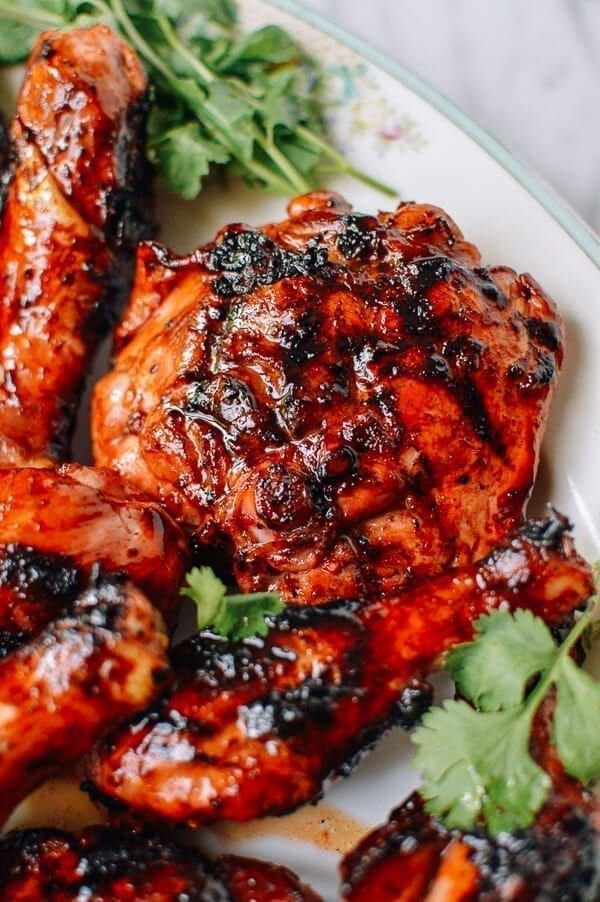 grilled chicken wings with cilantro and parsley garnish on a white plate