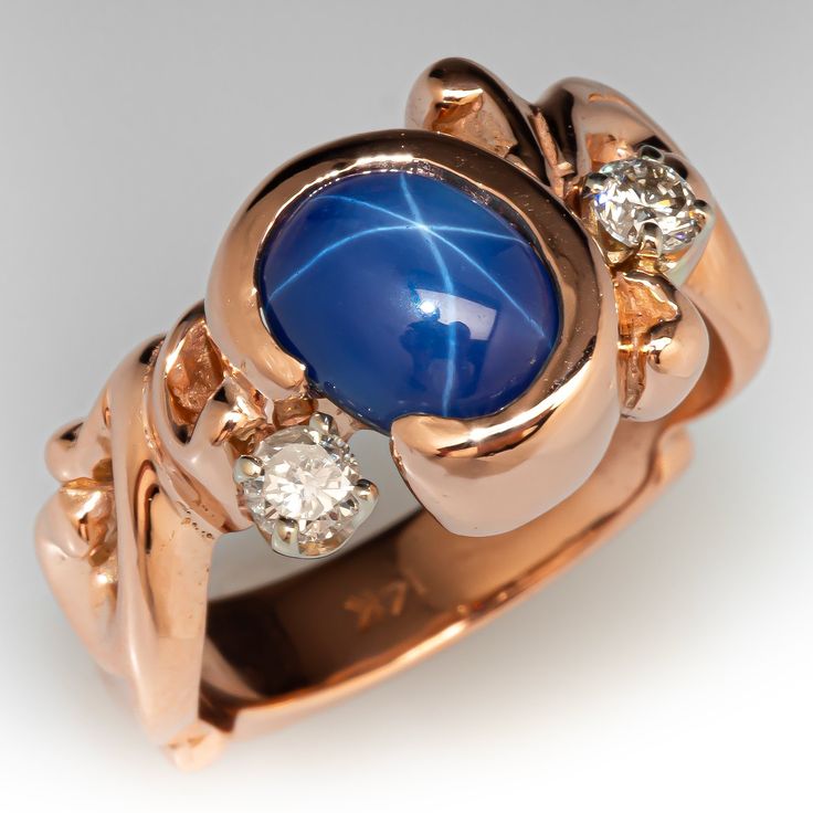 a gold ring with a blue stone surrounded by two white diamonds on the inside and outside