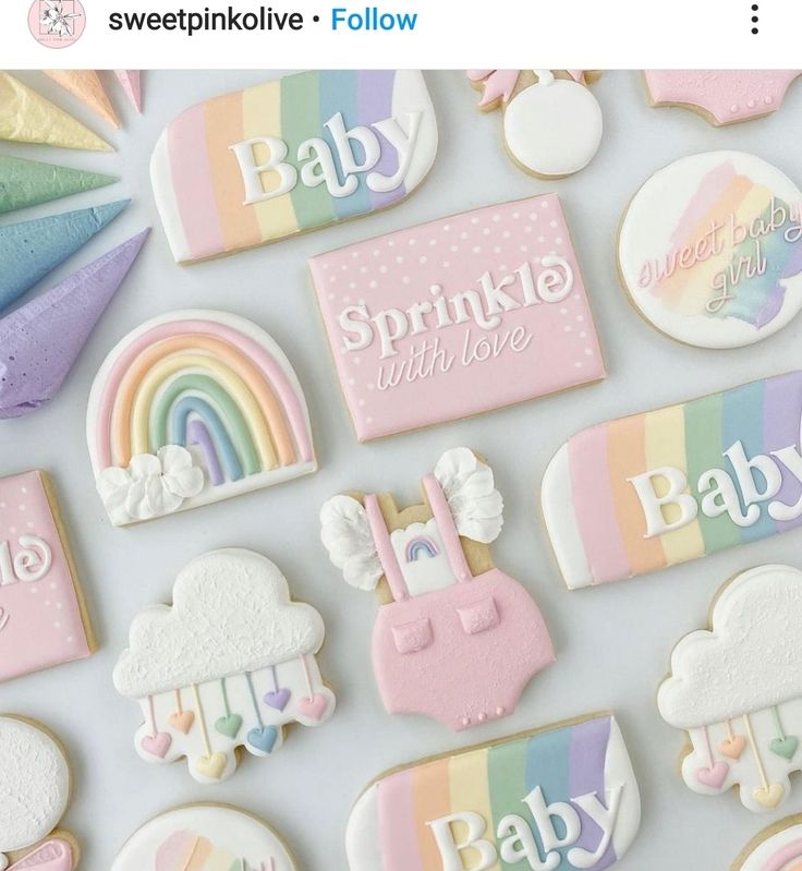 baby shower cookies decorated with pastel colors and rainbows are arranged on a white surface