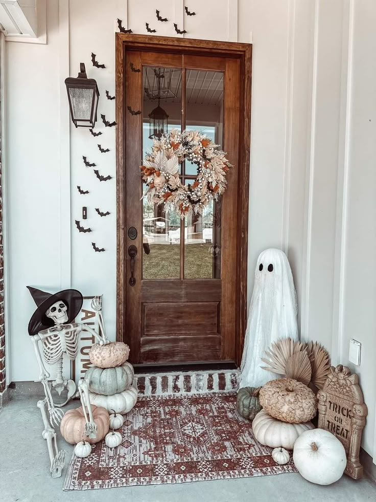 a front door decorated for halloween with pumpkins and decorations