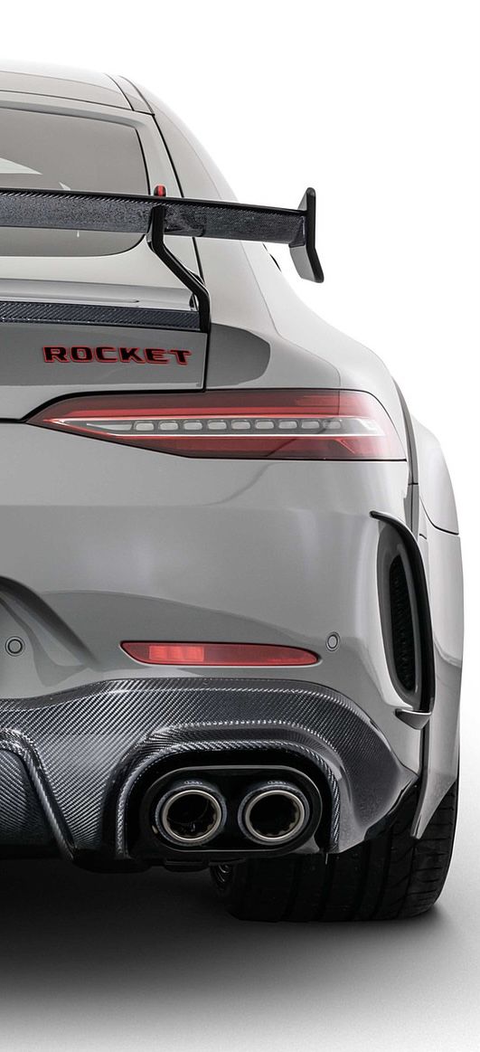 the rear end of a silver sports car with chrome exhaust pipe and tailpipes