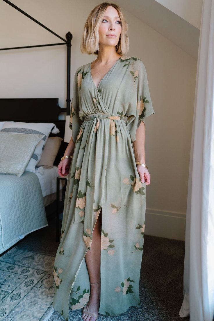 Our Kia Kimono Maxi Dress is perfect for any occasion! It features an olive and marigold floral print. This dress is great for maternity! Flowy Floral Maxi Dress With Surplice Neckline, Flowy Floral Dress With Surplice Neckline, Spring Dresses With Kimono Sleeves, Spring Flowy Dresses With Kimono Sleeves, Spring Dresses With Flowy Kimono Sleeves, Flowy Spring Dresses With Kimono Sleeves, Flowy Wrap Dress With Floral Print For Vacation, V-neck Floral Print Wrap Dress For Garden Party, Spring Dresses With Flowy Fit And Kimono Sleeves