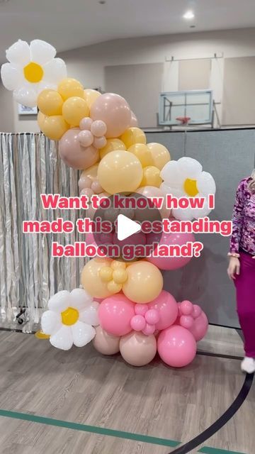 a woman standing next to a giant balloon arch with flowers on it and the caption says, want to know how i made this outstanding balloon garland?