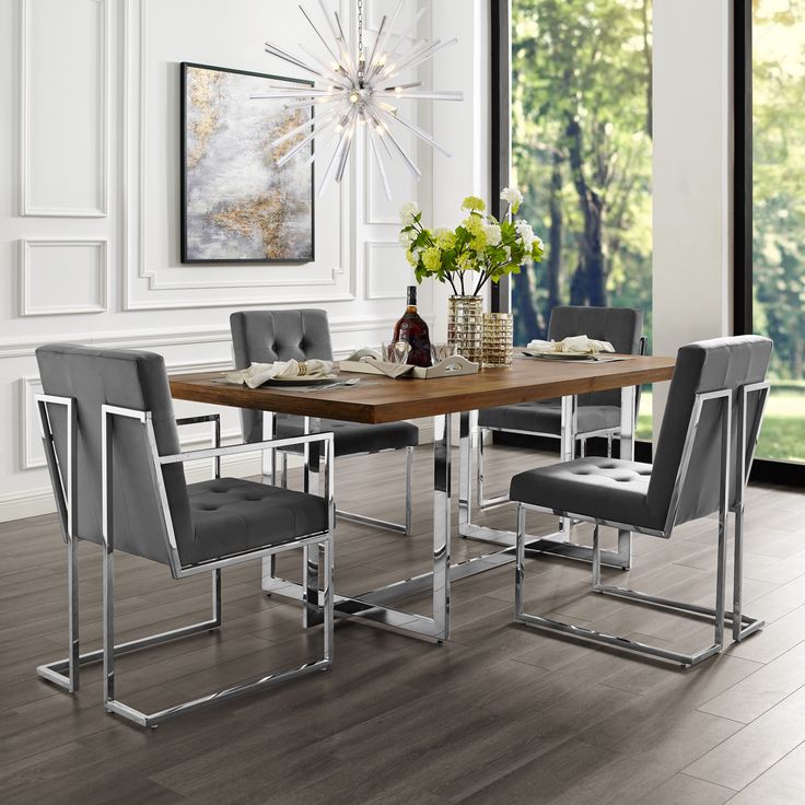 a dining room table with grey chairs and a large window