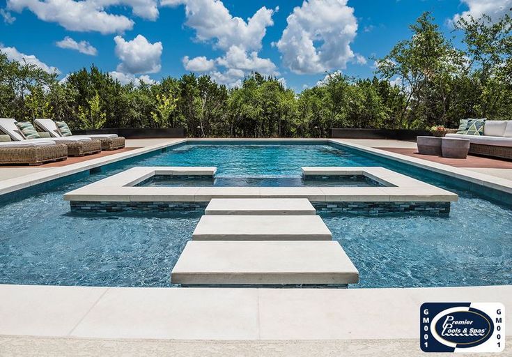 an outdoor swimming pool with steps leading up to it and lounge chairs around the edge