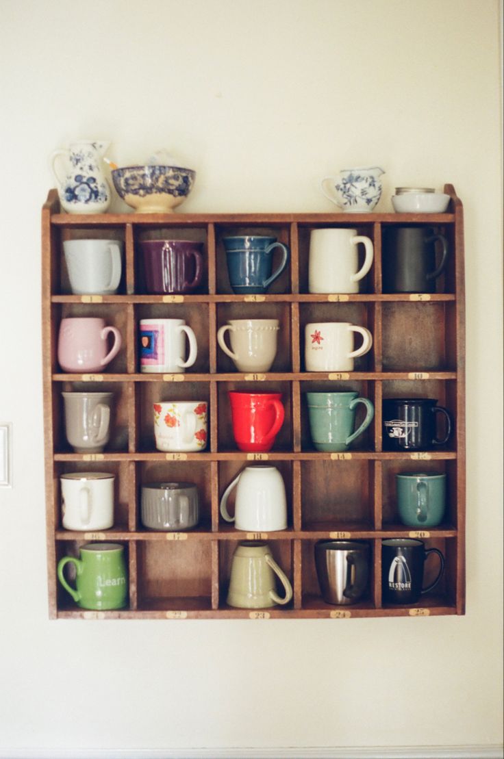 a wooden shelf filled with lots of cups