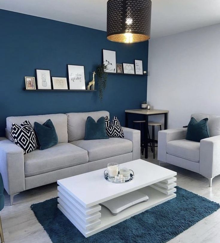 a living room with blue walls and white furniture