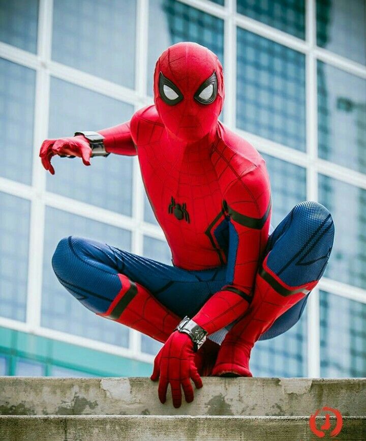 a man in a spider - man suit is sitting on a ledge