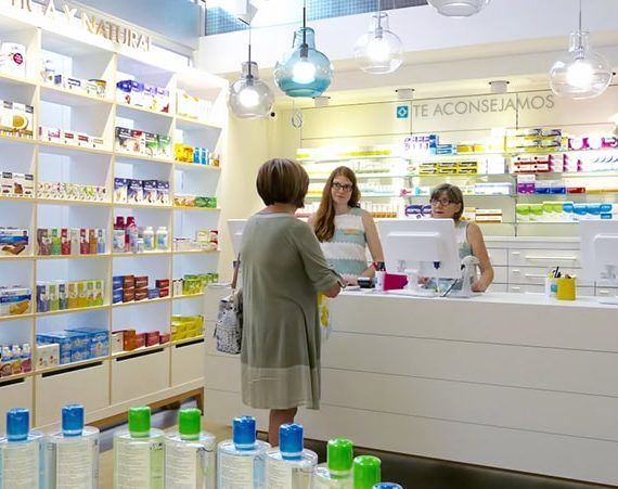 two women standing in front of a counter at a store