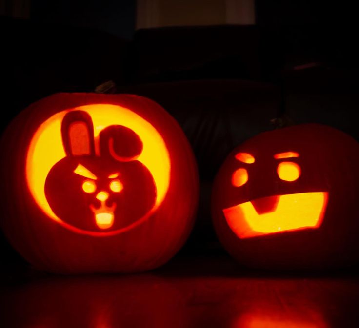 two pumpkins with faces carved into them