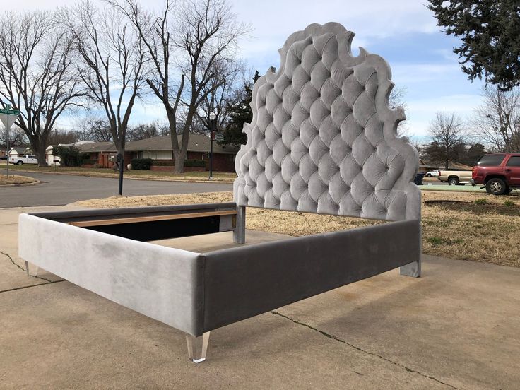 an upholstered bed sitting on top of a sidewalk