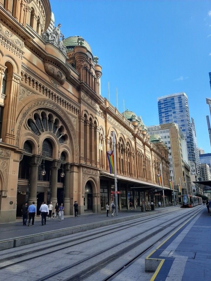 people are walking on the street in front of an old building