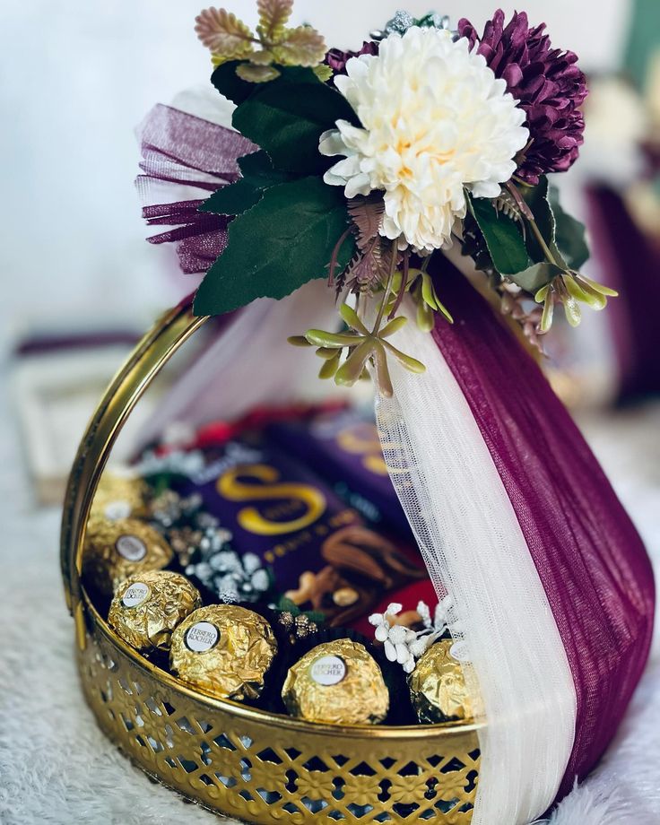 a basket filled with chocolates and flowers on top of a table