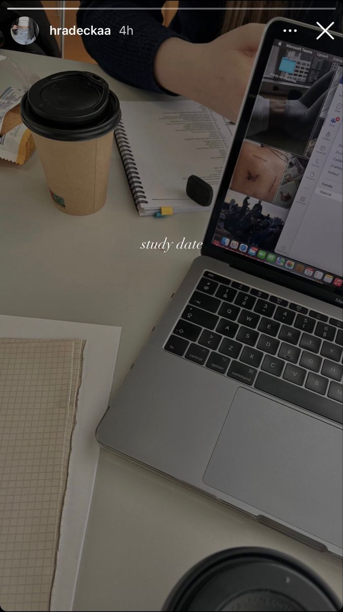 an open laptop computer sitting on top of a desk next to a cup of coffee