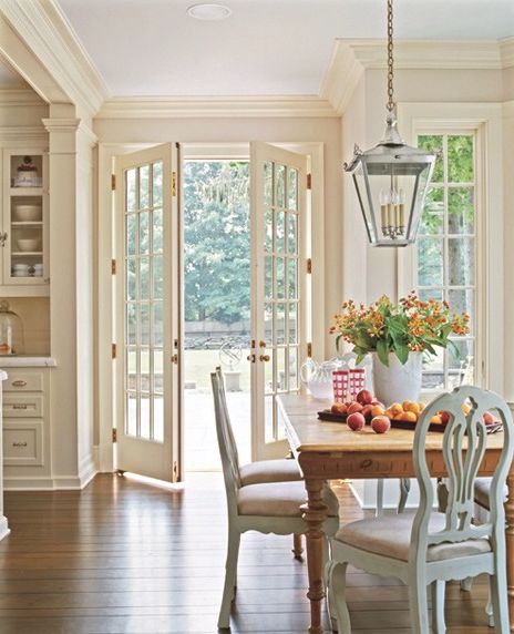 an image of a dining room with french doors and windows on the side of it