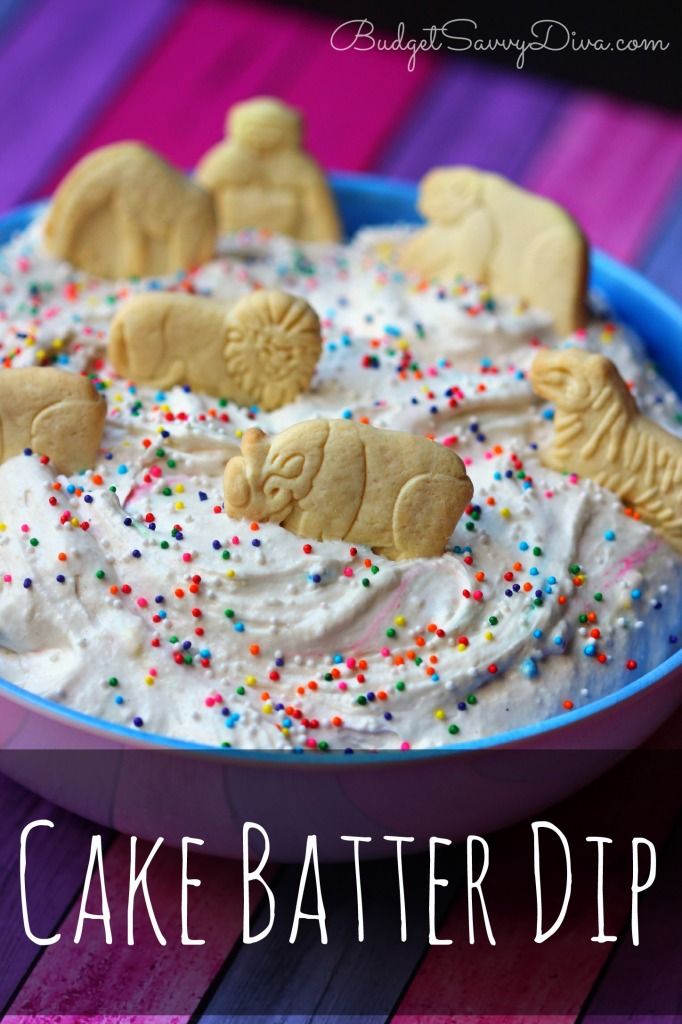 a blue bowl filled with white frosting topped with cookies and sprinkles