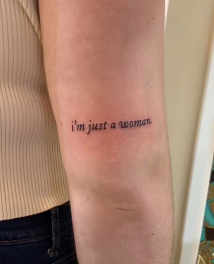 a woman with a tattoo on her arm that says i'm just a woman