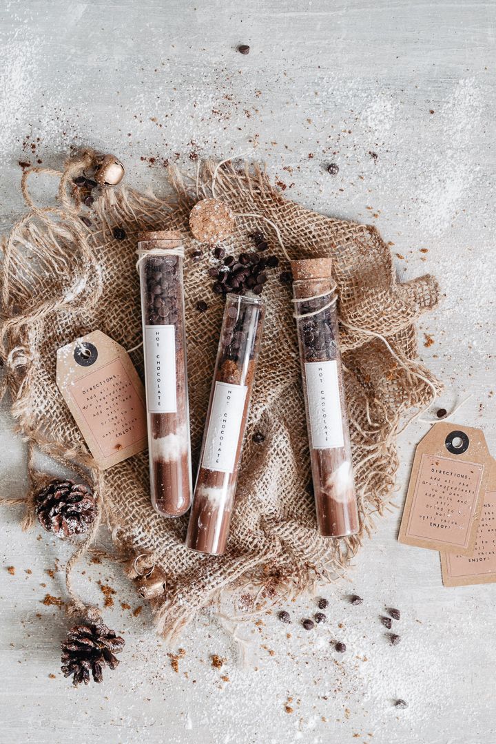 three tubes of cinnamon spice sitting on top of burlap next to pine cones