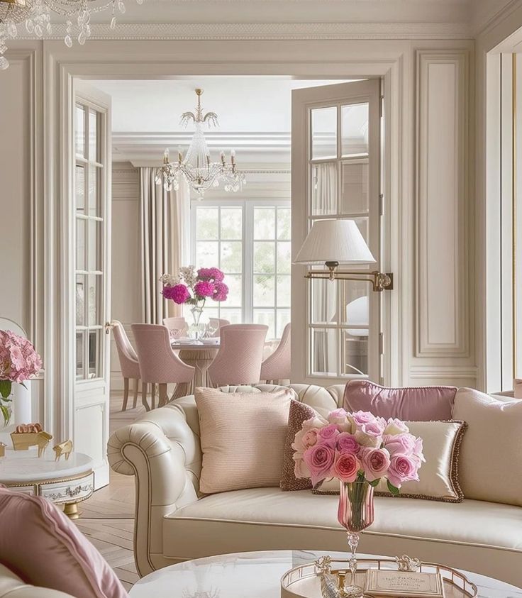 a living room filled with lots of furniture and flowers in vases on the coffee table