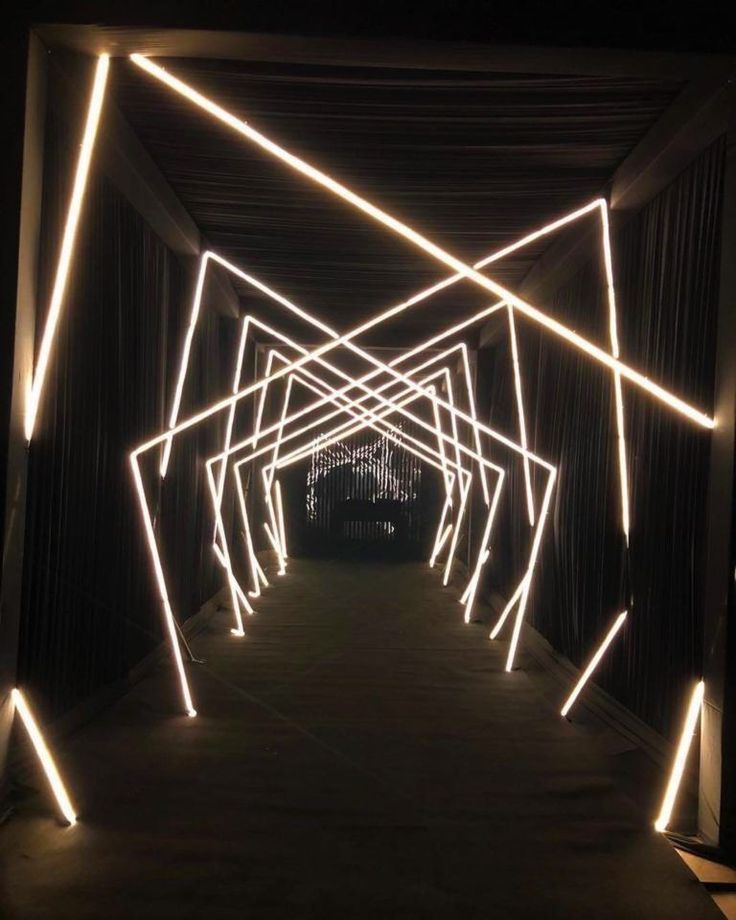 an illuminated tunnel in the dark with white lights